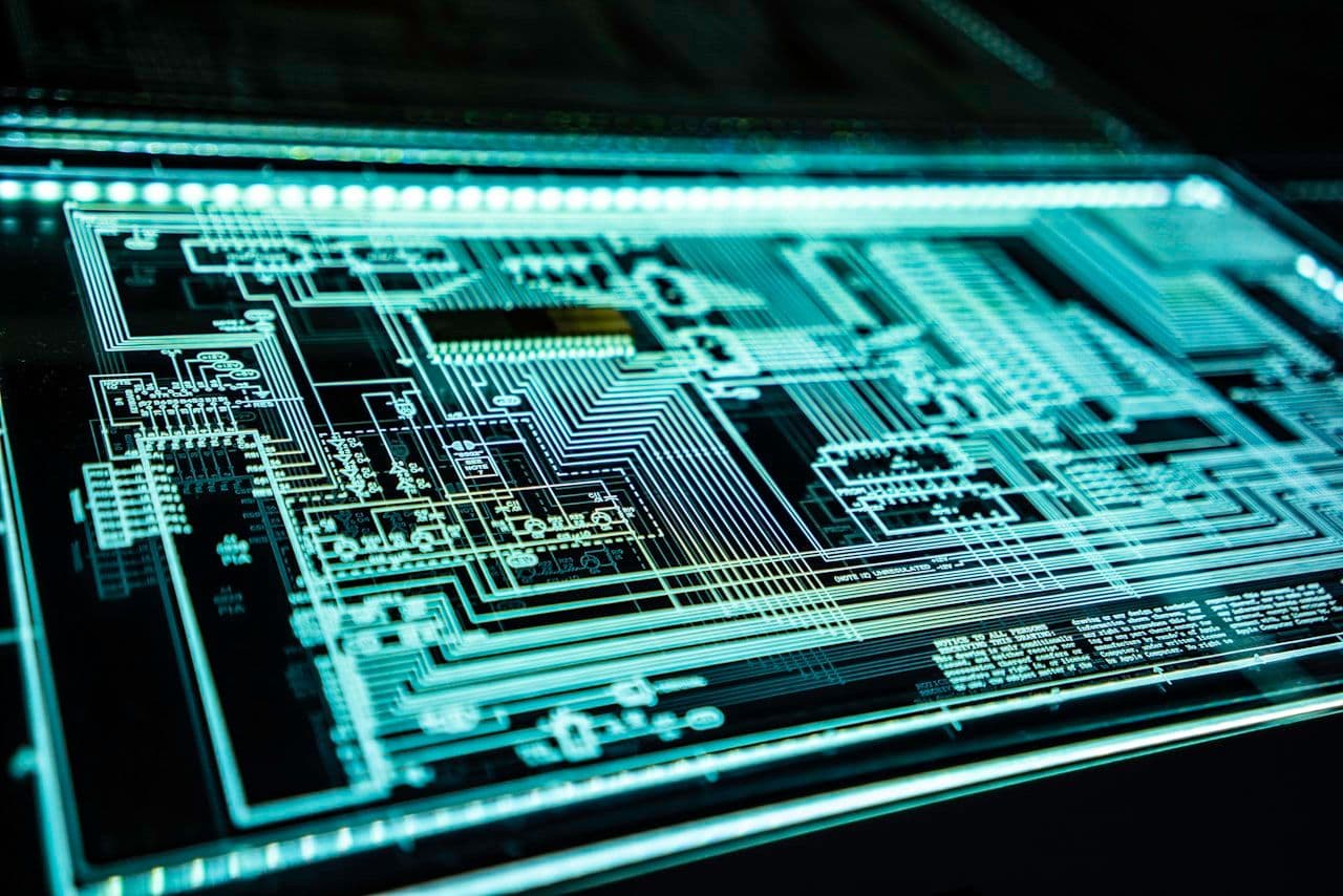 Illuminated circuit board representing the identity and access layer that underpins both cyber and insider risk